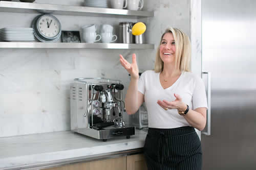 Renee Scharoff in her kitchen tossing a lemon